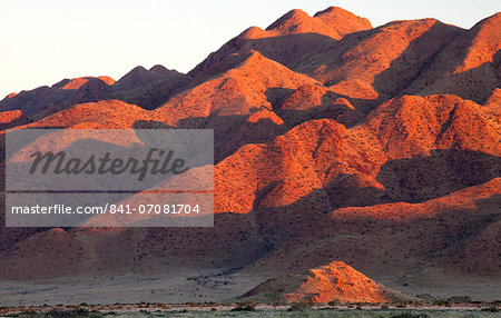 Sandstone mountains lit by the last rays of light from the setting sun, near Sesriem, Namib Desert, Namib Naukluft Park, Namibia, Africa