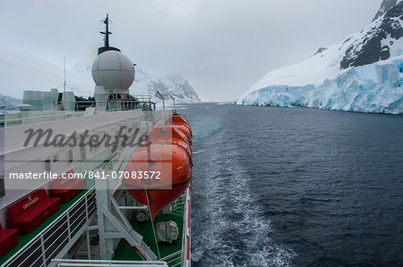 Cruise ship slowly passing through the Lemaire Channel, Antarctica, Polar Regions