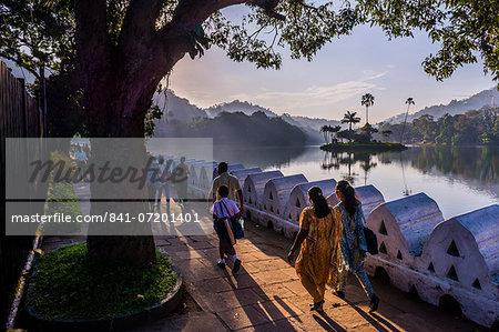 Sri Lankan people walking at Kandy Lake at sunrise, Kandy, Central Province, Sri Lanka, Asia