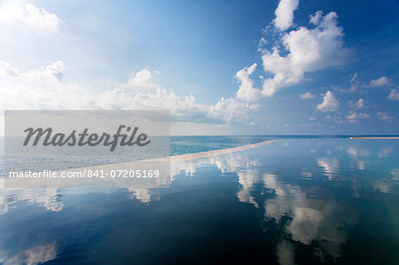 Infinity pool reflecting the sky and clouds with sea visible in the distance, Silavadee Pool Spa Resort, Koh Samui, Thailand, Southeast Asia, Asia