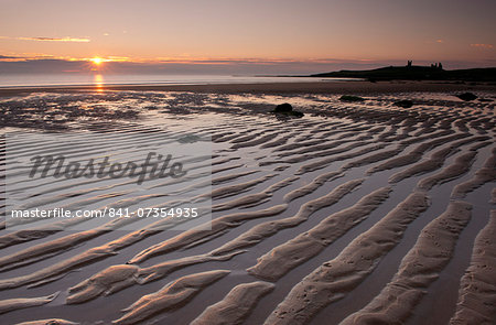 Ripples of sand near Dunstanburgh Castle in Embleton Bay at sunrise, Northumberland, England, United Kingdom, Europe