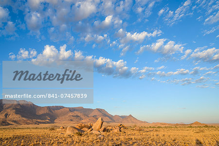 Boulders on the plains below the Brandberg mountain range at sunrise, Damaraland, Namibia, Africa