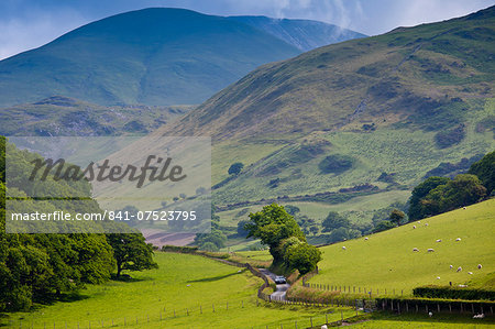 Car motoring along winding road through picturesque valley at Llanfihangel, Snowdonia, Gwynedd, Wales