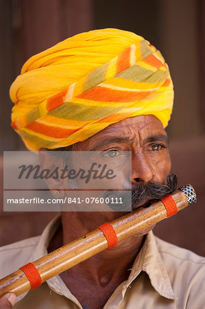 Hindu musician playing flute wind instrument at Mehrangarh Fort at Jodhpur in Rajasthan, Northern India