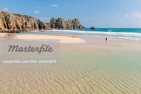 Woman walking alone on Pednvounder Beach at low tide, Porthcurno, Cornwall, England, United Kingdom, Europe