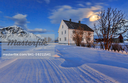 Typical house surrounded by snow on a cold winter day at dusk, Flakstad, Lofoten Islands, Norway, Scandinavia, Europe