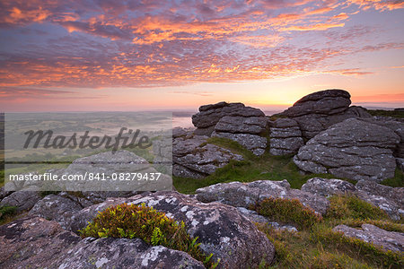 Spectacular sunrise in summer above the granite tor on Meldon Hill, Dartmoor National Park, Devon, England, United Kingdom, Europe