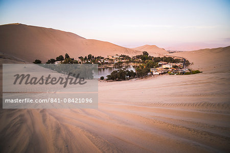 Huacachina and sand dunes at sunset in the desert in the Ica Region, Peru, South America