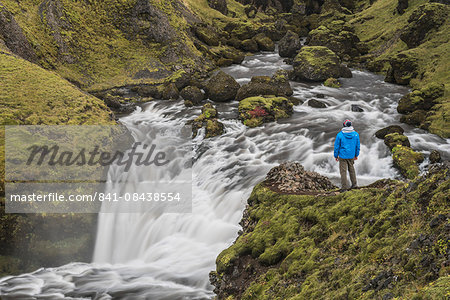 Tourist at a waterfall on the hiking trail above Skogafoss Waterfall, Skogar, South Region (Sudurland), Iceland, Polar Regions