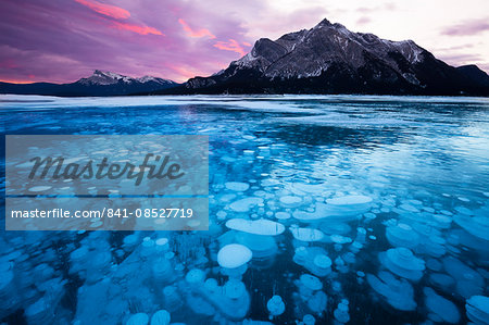 Bubbles and Cracks in the Ice with Mount Michener and Kista Peak in the Background at Sunrise, Abraham Lake, Alberta, Canada, North America