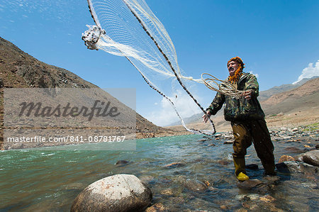 A man from the Panjshir Valley fishes with a throw-net