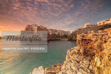 Pink sunrise on the turquoise sea framed by old town perched on the rocks, Polignano a Mare, Province of Bari, Apulia, Italy, Europe