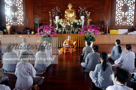 A teacher instructs a group of people how to recite Buddhist chants, Minh Dang Quang Buddhist Temple, Ho Chi Minh City, Vietnam, Indochina, Southeast Asia, Asia