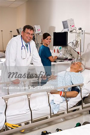 Doctor And Nurse With Patient In Recovery Room Stock Photo