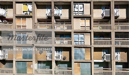 Detail of a derelict block in the Park Hill Estate, Sheffield, with brightly coloured graffitti art on boarded up windows. Architects: Jack Lynn and Ivor Smith