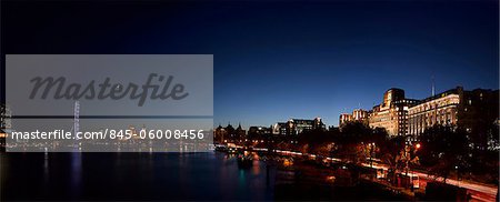 River Thames London panorama at dusk with the Savoy Hotel on the right and the London Eye to the left.