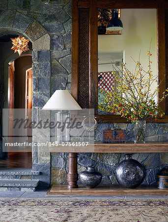 Wooden mirror above table in hallway of USA home