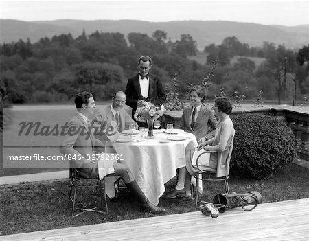 1920s 1930s COUNTRY CLUB SCENE WITH TWO COUPLES WITH GOLF CLUBS HAVING LUNCH OUTDOORS