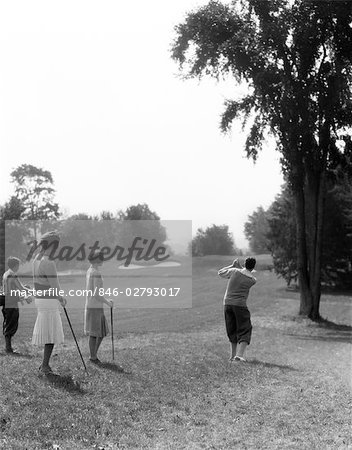 1920s 1930s MALE GOLFER DRIVING DOWN FAIRWAY TWO WOMEN AND CADDY LOOK ON AT THE BERKSHIRE HOTEL & COUNTRY CLUB MA