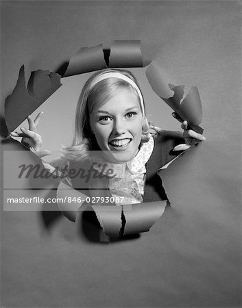 1960s BLOND WOMAN BREAKING THROUGH RIPPED PAPER SMILING WEARING HEADBAND