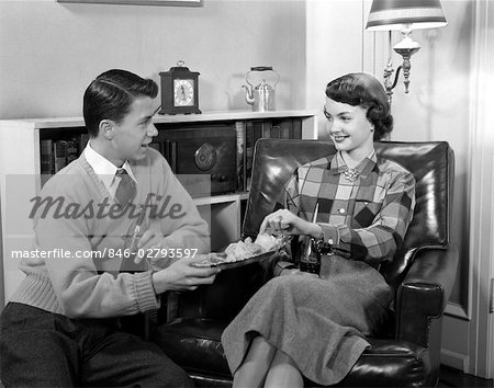 1950s BOY GIRL YOUNG TEEN COUPLE DATING SITTING IN CHAIR DRINKING COKES EATING POTATO CHIPS