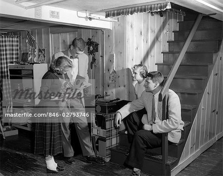 1950s GROUP TEENS BOYS GIRLS PLAYING RECORDS ON PHONOGRAPH KNOTTY PINE REC ROOM