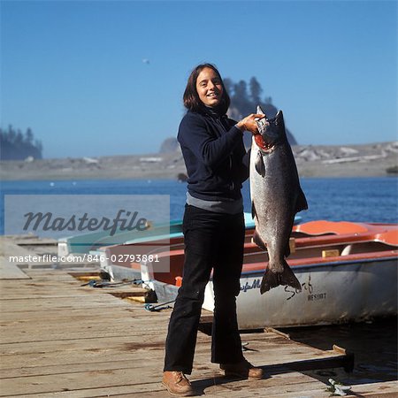 Young Woman On Beach Holding Fishing Rod And Salmon Portrait High