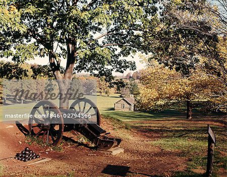 1960s AUTUMN SCENE AT VALLEY FORGE NATIONAL PARK WITH CANNON AND LOG CABIN