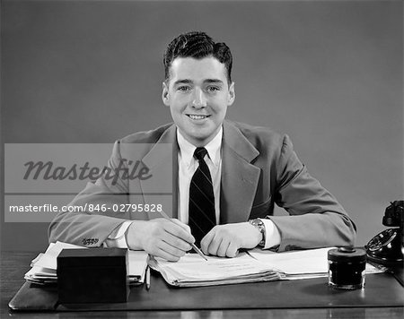 1940s MAN SITTING AT DESK IN OFFICE