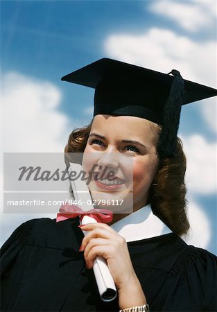 1940s 1950s SMILING FEMALE GRADUATE HOLDING DIPLOMA WRAPPED IN RED RIBBON