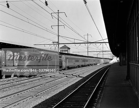 1940s PENNSYLVANIA RAILROAD STREAMLINE ELECTRIC POWERED GG1 LOCOMOTIVE PULLING PASSENGER TRAIN OUT OF STATION