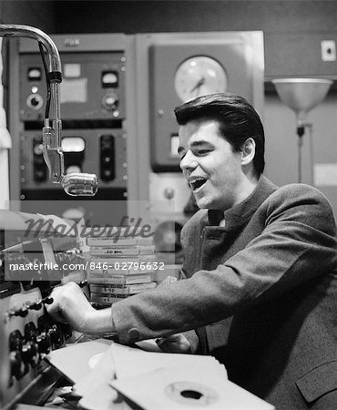1960s SIDE VIEW OF RADIO DISC JOCKEY IN STUDIO ANNOUNCING 1960s SIDE VIEW OF RADIO DISC JOCKEY IN STUDIO ANNOUNCING