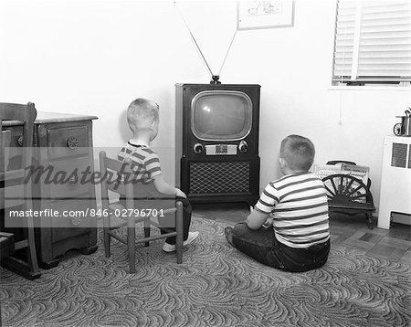 1950s BACK VIEW OF 2 BOYS IN STRIPED T-SHIRTS WATCHING TV