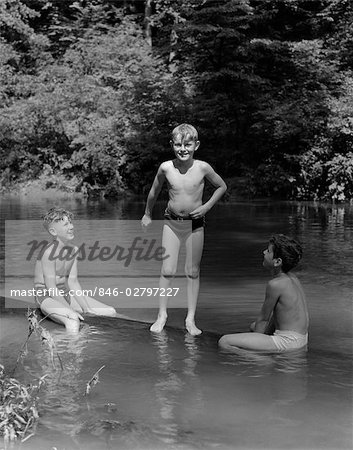 1940s THREE BOYS OUTDOOR IN SWIMMING HOLE - Stock Photo