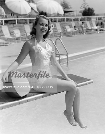 1950s BATHING BEAUTY IN SATIN ONE PIECE SITTING ON DIVING BOARD