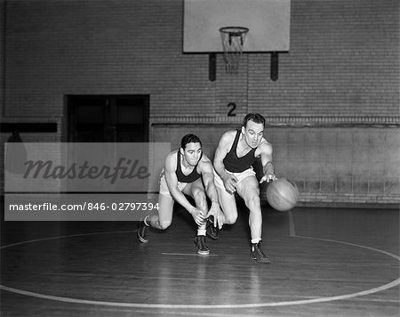 1930s TWO BOYS PLAYING BASKETBALL INSIDE COURT DRIBBLING BASKETBALL