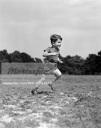 1940s CHILD RUNNING PLAYING ON GRASS FIELD