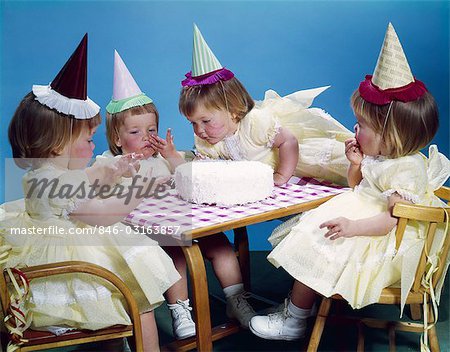 1950s 1960s QUADRUPLETS 4 RED HAIRED GIRLS WEARING PARTY HATS AND DRESSES SITTING TABLE BIRTHDAY CAKE