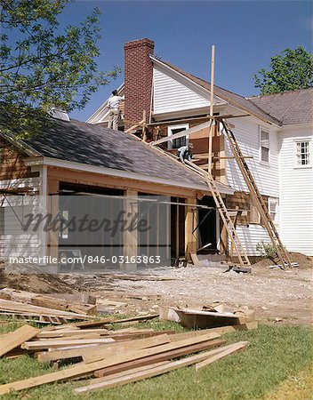 1960s 1970s Workers Building Two Car Garage Addition Onto Suburban