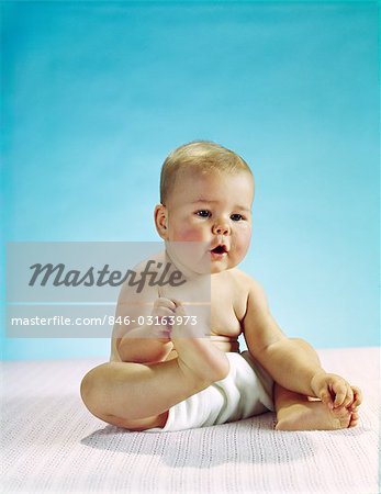 1960s BABY SITTING HOLDING ON TO HIS FEET