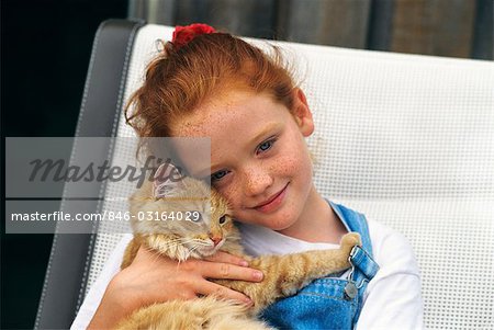 GIRL HOLDING ORANGE TABBY CAT