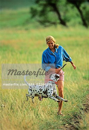 BLONDE WOMAN AND DALMATIAN OUTDOORS