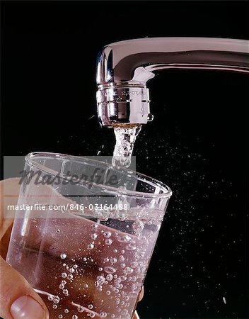 Filling glass of water featuring water, glass, and hand