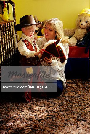 1970s MOM & LITTLE BOY DRESSED AS COWBOY RIDING A STICK HORSE