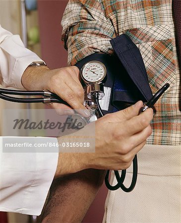 1970s CLOSE UP OF DOCTOR READING MANS BLOOD PRESSURE