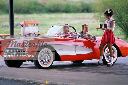 YOUNG COUPLE IN DRIVE-IN BEING SERVED DRINKS GRANBY COLORADO