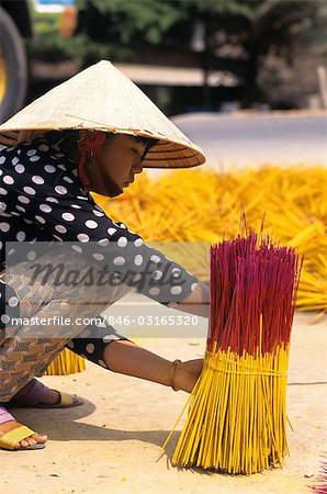 MEKONG, VIETNAM WOMAN SELLING INCENSE IN MARKETPLACE