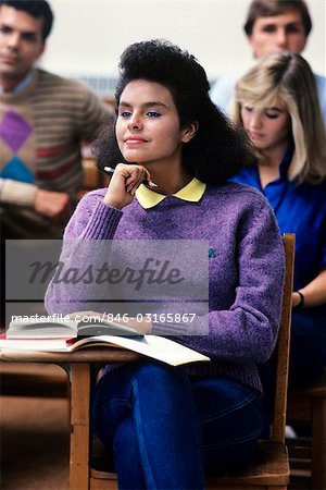 1980s ATTENTIVE FEMALE COLLEGE STUDENT PURPLE SWEATER IN CLASSROOM