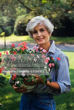 WOMAN HOLDING FLOWERING PLANT