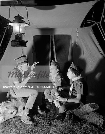 1960s 3 BOY SCOUTS SITTING TENT NIGHT TELLING GHOST STORIES